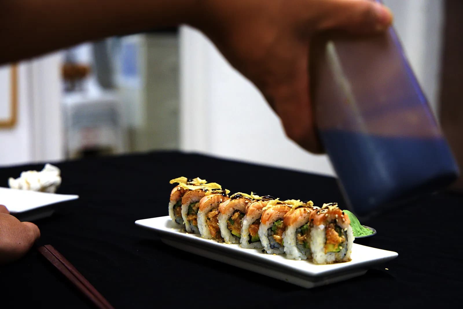 Sauce teriyaki versée sur un roll au saumon snacké