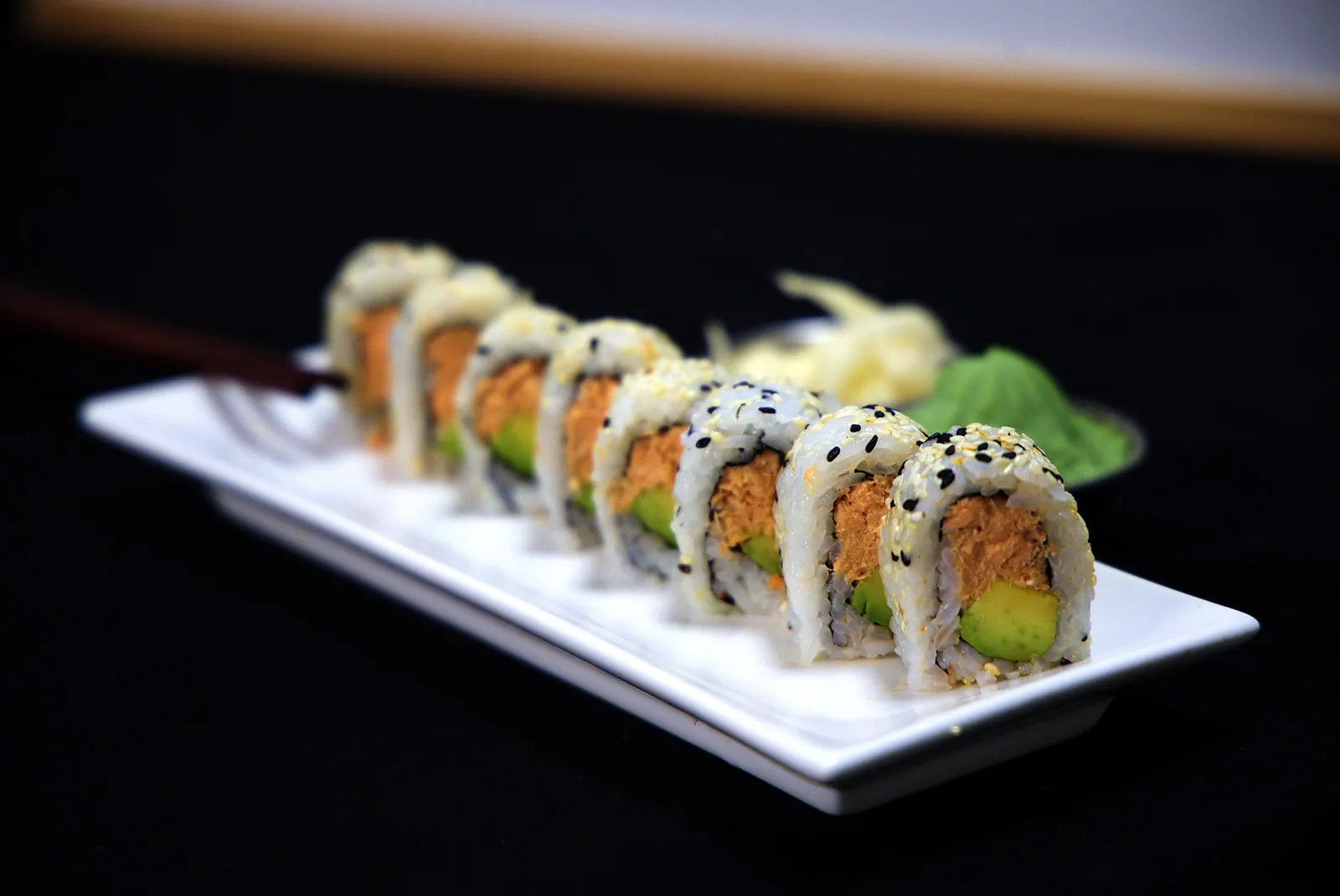 Baked salmon and avocado roll coated in sesame